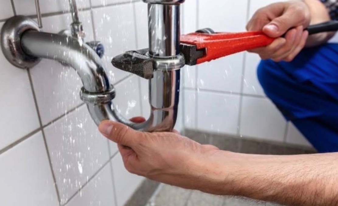Hydraulik podczas naprawy instalacji pod umywalką